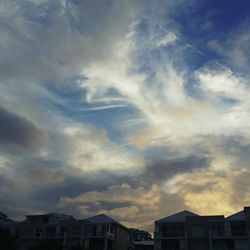 Low angle view of buildings against cloudy sky