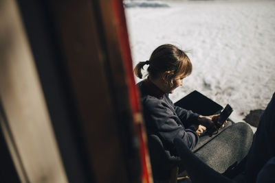 Businesswoman using smart phone during winter