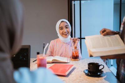 Portrait of young woman sitting on table