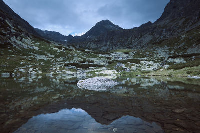 Scenic view of lake by mountains against sky