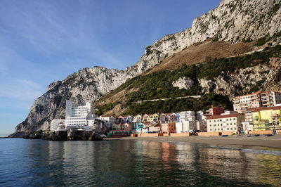 Scenic view of village buildings and a hotel in the bay with a rock in a background 