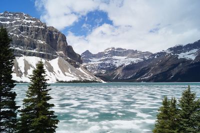 Scenic view of lake by mountains against sky