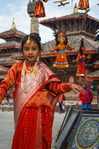 Portrait of girl in traditional clothing standing at temple