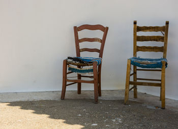 Empty chair on table against wall