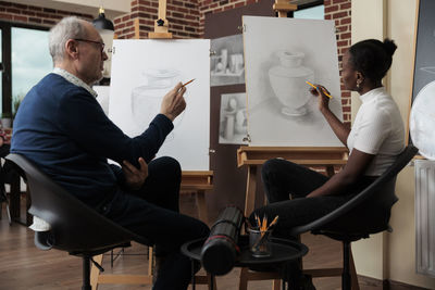 Teacher explaining student during drawing class