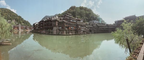 Panoramic view of lake and buildings against sky