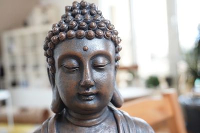 Close-up of buddha statue against building