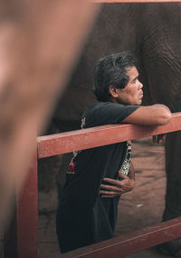 Side view of man looking at camera