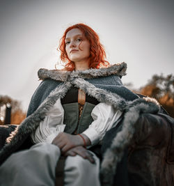 Portrait of young woman sitting on sofa in forest