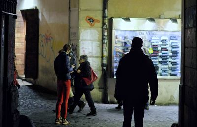 Rear view of people walking on street in city