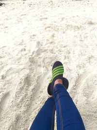 Low section of man standing on beach