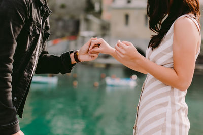 Midsection of couple holding hands