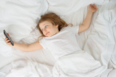 High angle view of boy lying on bed