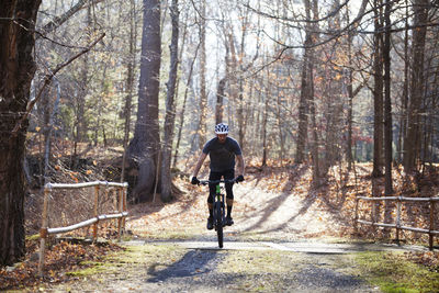 Man mountain biking in forest