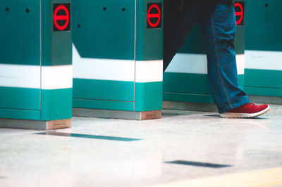 Low section of man walking by turnstile