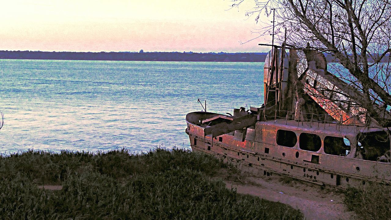 water, sea, sky, horizon over water, built structure, tranquility, architecture, nature, transportation, tranquil scene, river, beach, no people, tree, outdoors, scenics, shore, moored, clear sky, building exterior