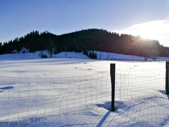 Snow covered field against sky