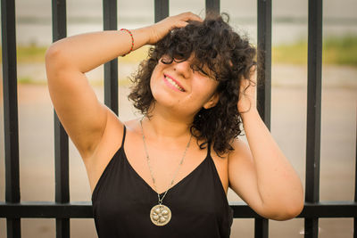 Close-up of smiling woman with hand in hair