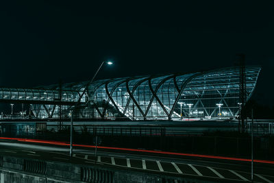 Light trails on bridge against sky at night