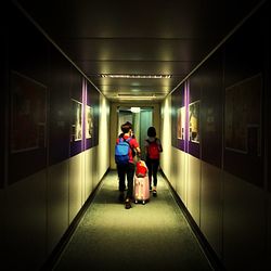 Rear view of people walking in corridor