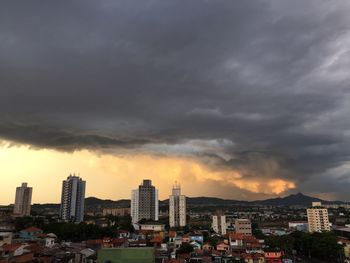 Storm clouds over city at sunset