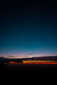 Illuminated road against sky at night