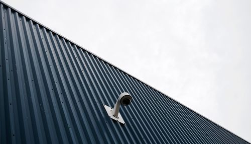 Low angle view of bird on roof against sky