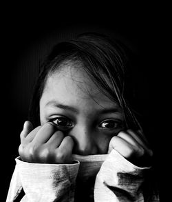 Close-up portrait of cute girl against black background