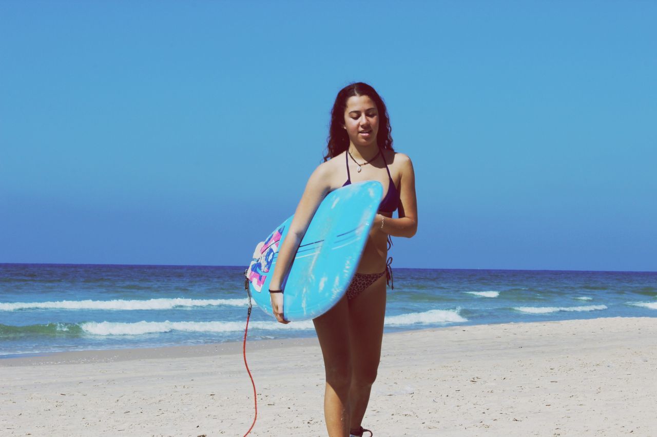 beach, sea, horizon over water, sand, shore, young adult, water, lifestyles, clear sky, leisure activity, vacations, person, copy space, young women, portrait, looking at camera, casual clothing