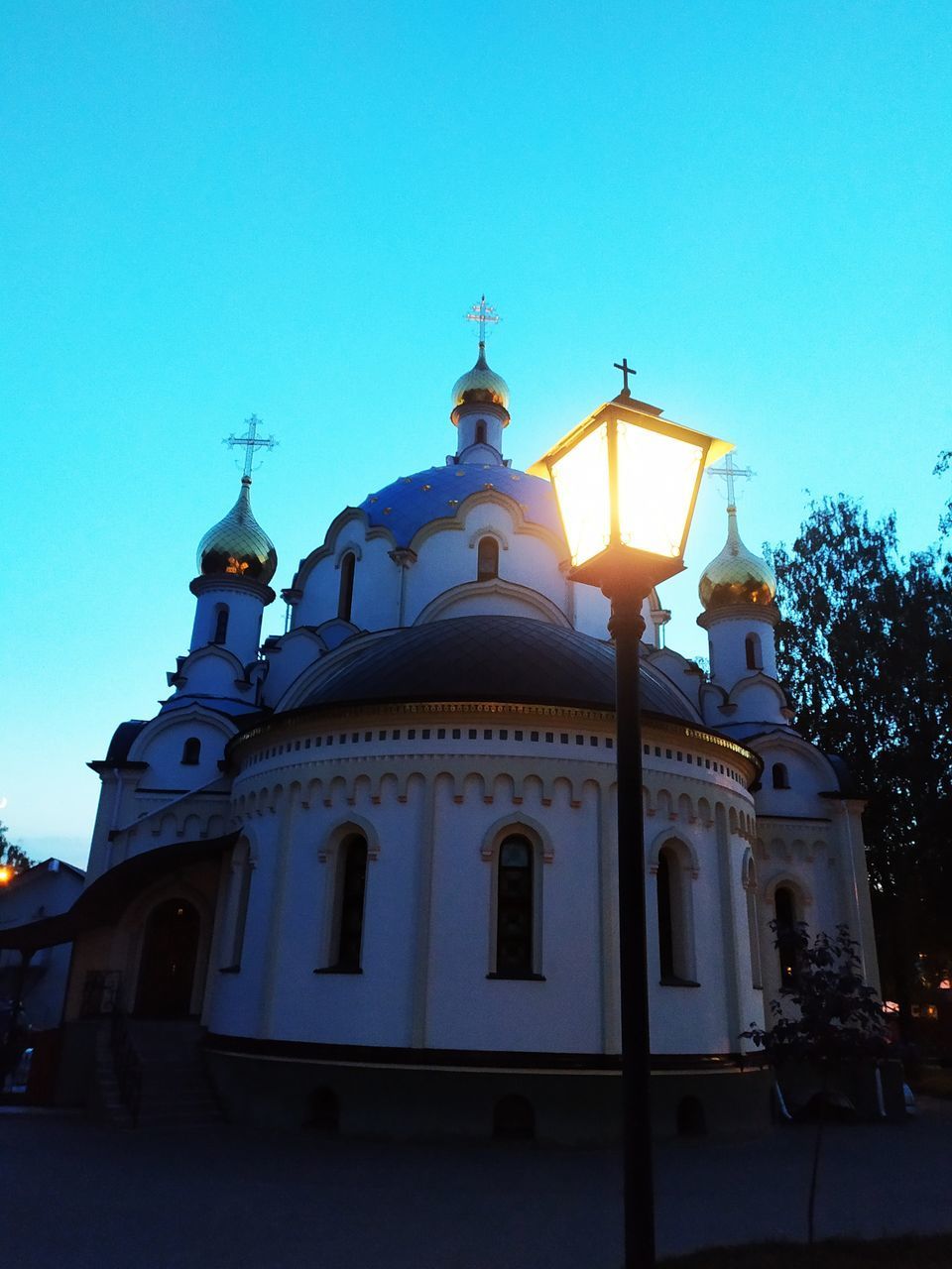 LOW ANGLE VIEW OF CHURCH AGAINST BUILDING AGAINST CLEAR BLUE SKY