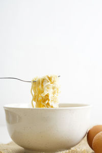 Close-up of bowl on table against white background