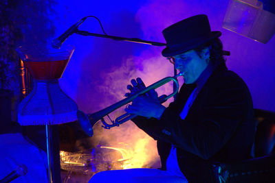 Side view of man playing music at night