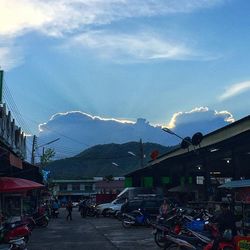 Cars on road against sky in city