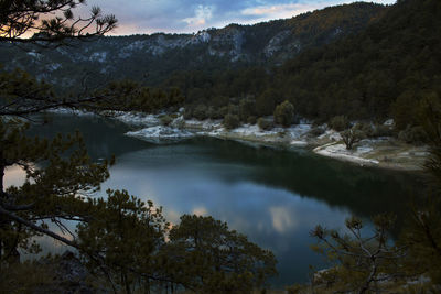 Scenic view of lake by trees against sky