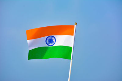 Low angle view of flag against blue sky