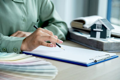 Midsection of person reading book on table