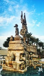 Low angle view of sculpture against cloudy sky