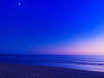 Scenic view of sea against clear sky at night