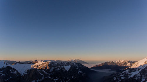 Scenic view of snowcapped mountains against clear sky during winter