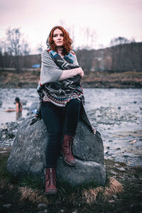 Portrait of young woman standing on rock