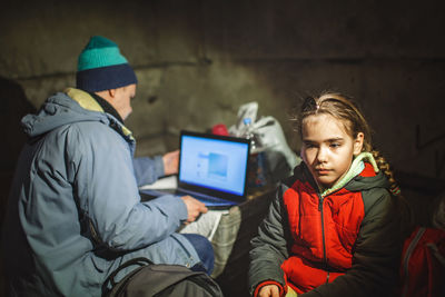 Ukrainian girl and journalist sit in bomb shelter, he works and posts news about russian invaders