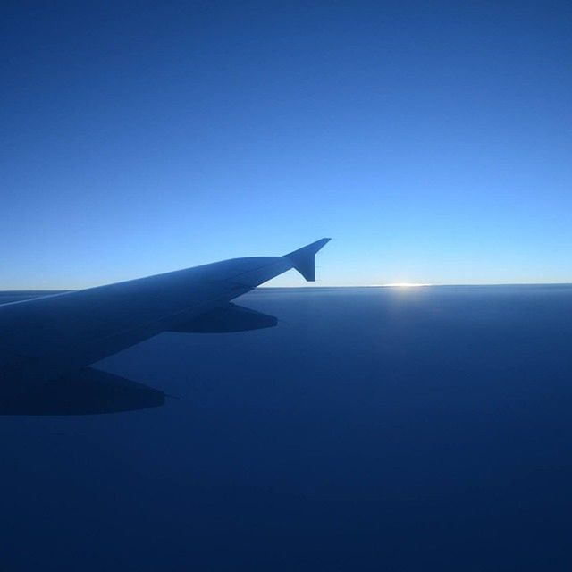 blue, clear sky, flying, copy space, airplane, air vehicle, part of, aircraft wing, cropped, mid-air, beauty in nature, nature, transportation, scenics, travel, sky, mode of transport, aerial view, tranquility, silhouette