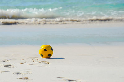 Close-up of yellow ball on beach