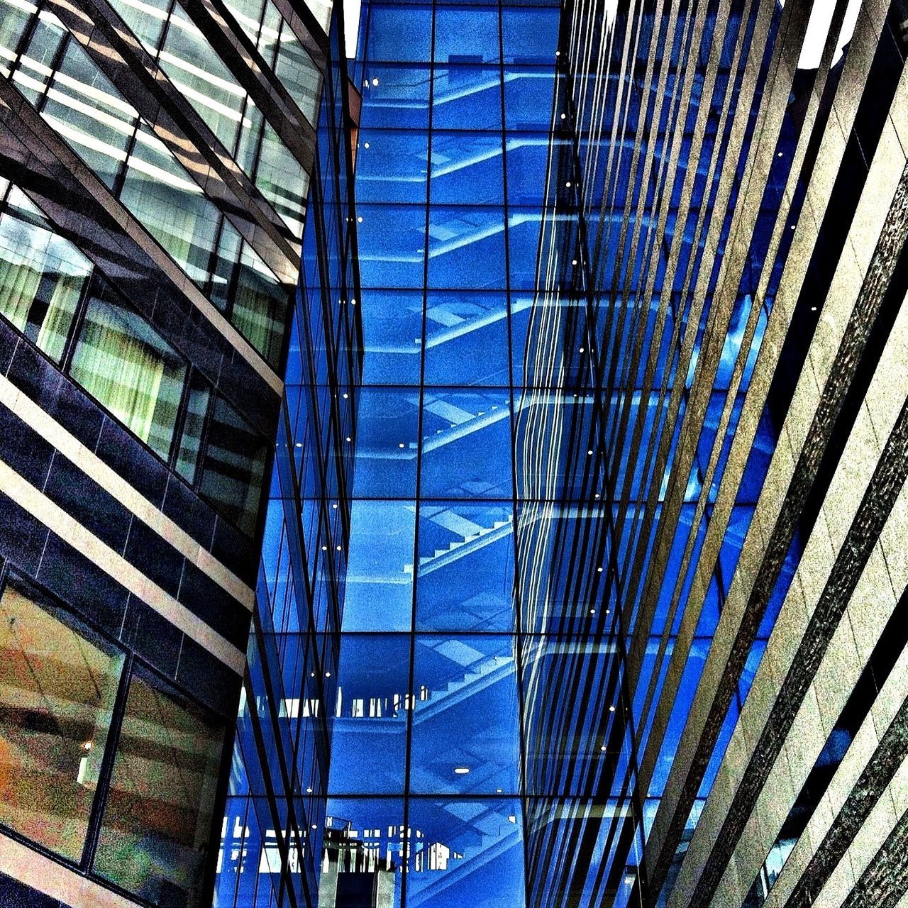 architecture, built structure, low angle view, modern, building exterior, glass - material, blue, pattern, office building, city, full frame, building, reflection, day, backgrounds, architectural feature, grid, no people, tall - high, ceiling
