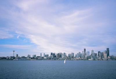 Sea by buildings against sky in city