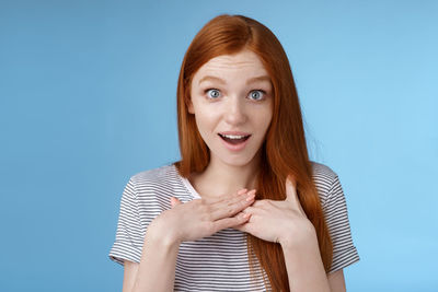 Beautiful woman admiring self against blue background