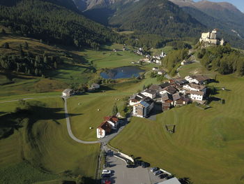 High angle view of houses on field by mountain