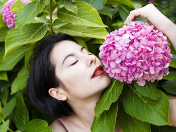 Close-up of woman with pink flower