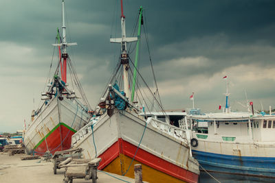 Two phinisi ships are docked at the port of paotere, makassar, indonesia.