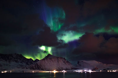 Aurora polaris over lake against sky
